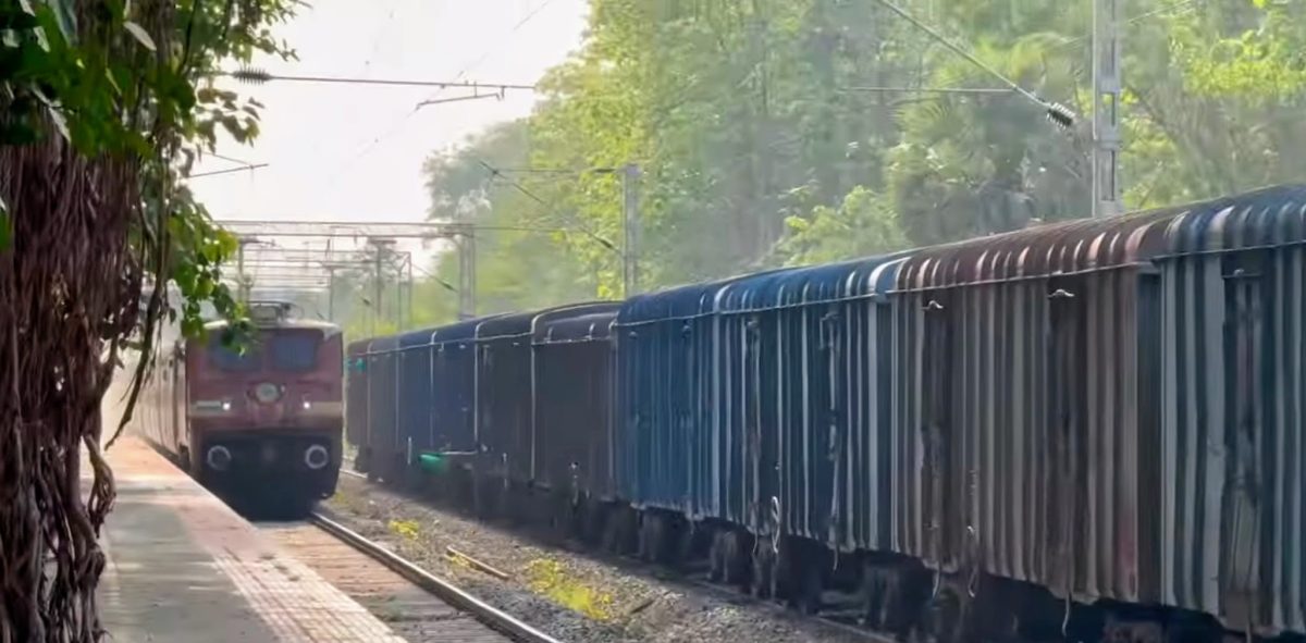 Passenger Train Passing Muthalamada Railway Station as Freight Train Waits on Adjacent Track